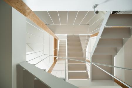 各スペースを繋ぐ階段を見上げる (上大崎の家)