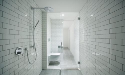 グレーのタイル張りシャワールーム・トイレ｜桜新町の家