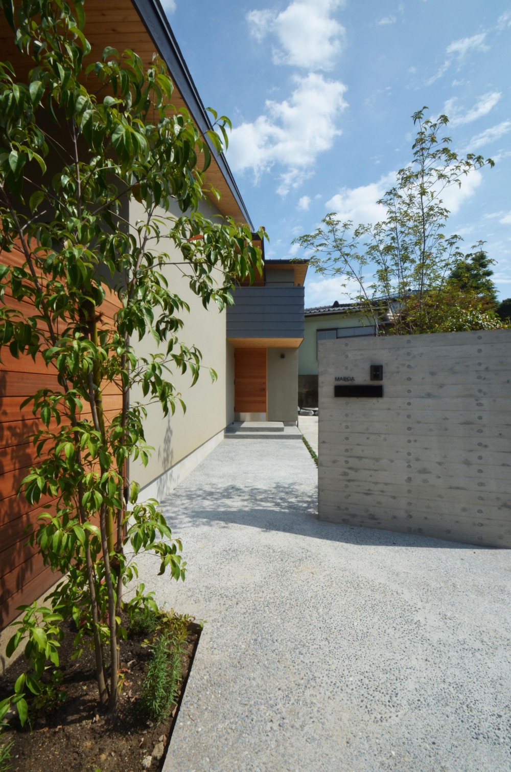 元石川町Ｍ邸－おおらかな片流れ屋根の下から望む眺めの家－ (玄関へのアプローチ)