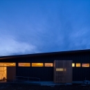 平屋・回廊の家の写真 黒いガルバリウム鋼板の外観(夕景)