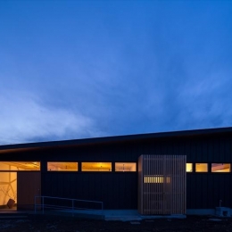 平屋・回廊の家 (黒いガルバリウム鋼板の外観(夕景))