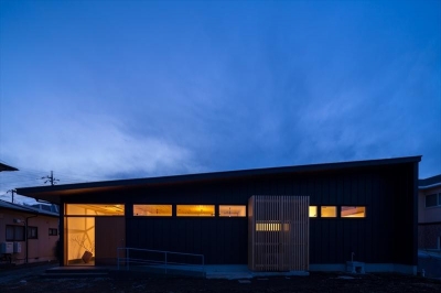 黒いガルバリウム鋼板の外観(夕景) (平屋・回廊の家)