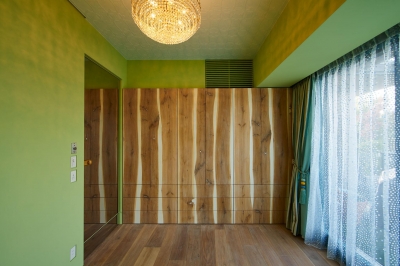 収納棚が印象的な緑色の壁の洋室 (G/E-HOUSE)