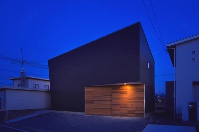 ビルトインガレージの黒い外観(夜景) (トンガリ壁の家)