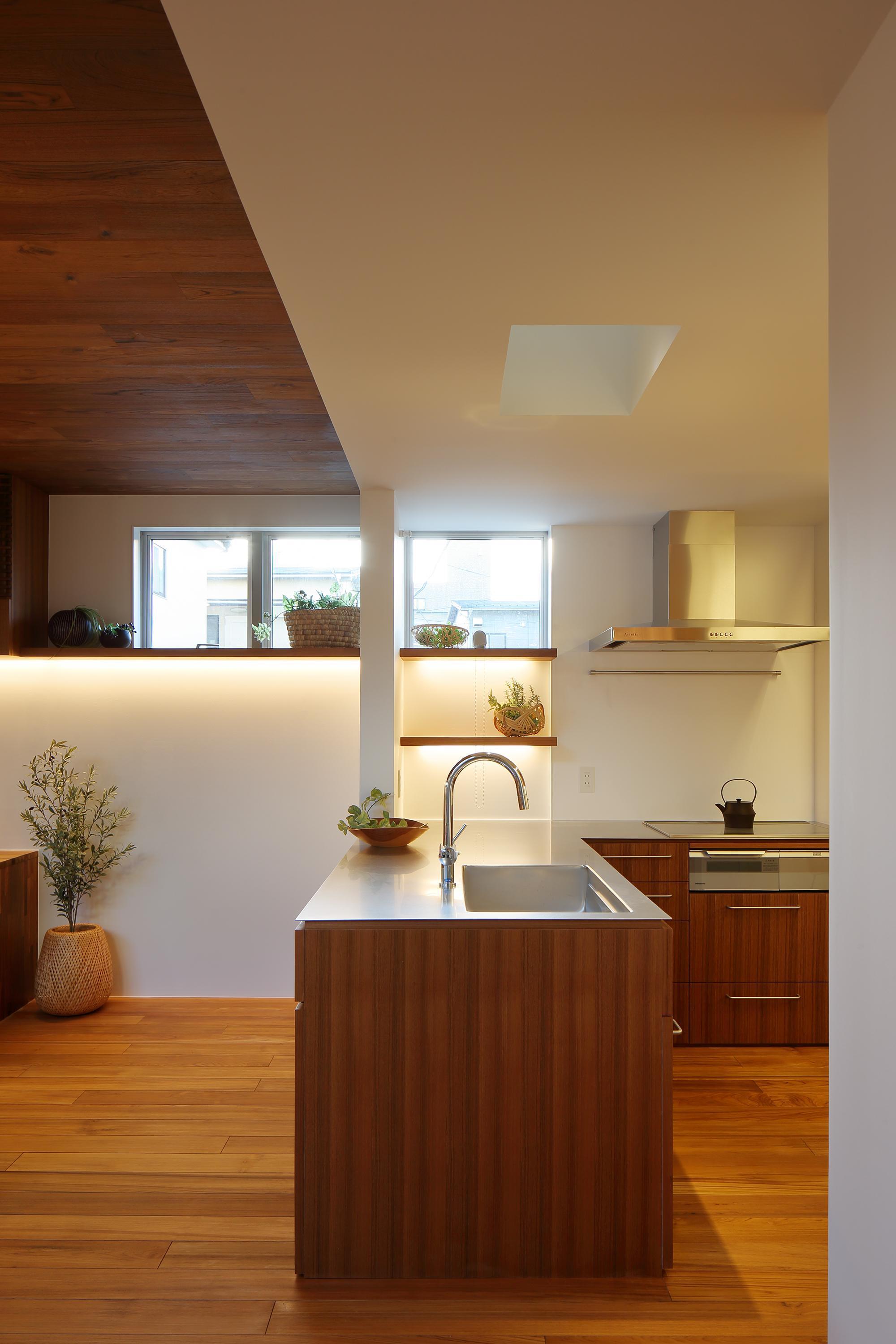 キッチン事例：キッチン。上部ガラス床から光が射し込む（三角の吹抜けのあるチークの家  ( 奥沢の家 )）