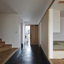 建築の中にある通り土間に向い合って住まう2世帯住宅インナーバイクガレージと趣味室　：　木津川の住宅の写真 全体を眺める