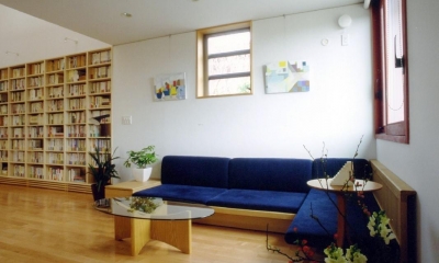 本棚に囲まれた一室空間の家 (コーナーにしつらえられた落ち着いたソファーコーナーです。)