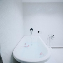 アーバンライフを楽しむマンションリノベーションの写真 白で統一された清潔感あふれるバスルーム