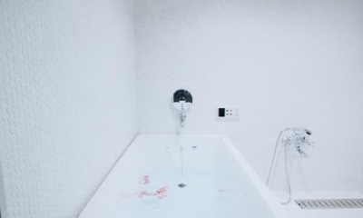 アーバンライフを楽しむマンションリノベーション (白で統一された清潔感あふれるバスルーム)