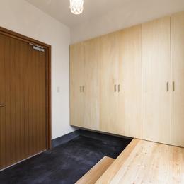 木製ドアと墨色土間ある玄関 (今戸コートハウス)