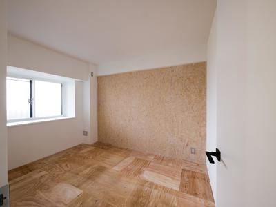 荒削りな雰囲気の床と壁の寝室 (木とモノトーンの調和した家)