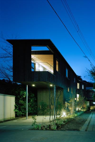 路地に沿う、北鎌倉の超細長い家 (路地に沿って曲がった焼杉の外観)