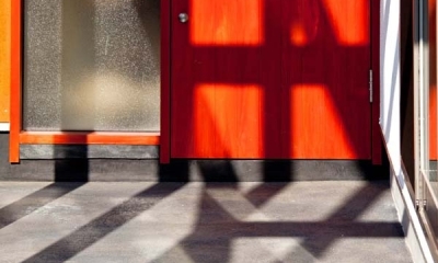 木格子の家／石神井台の二世帯住宅 (炭入りモルタルの床面とベンガラ塗装の玄関ドア)