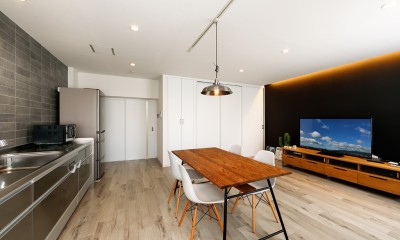 ブラック調のアクセントクロスがインパクトのあるリビング｜上質キッチンが映えるシンプル＆モダンな空間