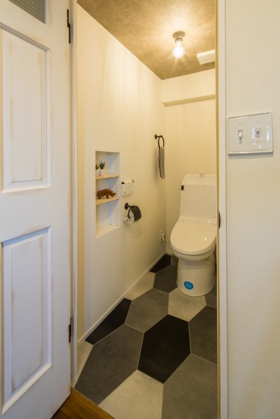 六角形の床が目を引くトイレ (アウトドアリビングの暮らしを楽しめる家)