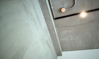 素材感のある壁･天井｜壁・天井もキッチンカウンターもモルタル仕上げの無骨でラフなマンションリノベーション