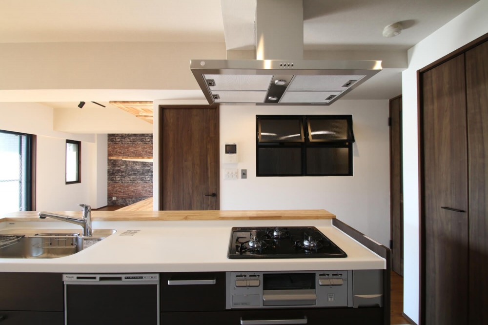 レンガ調のアクセントクロスと収納力抜群の壁面可動棚のLDK部分リノベーション (キッチン)