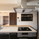 レンガ調のアクセントクロスと収納力抜群の壁面可動棚のLDK部分リノベーションの写真 キッチン