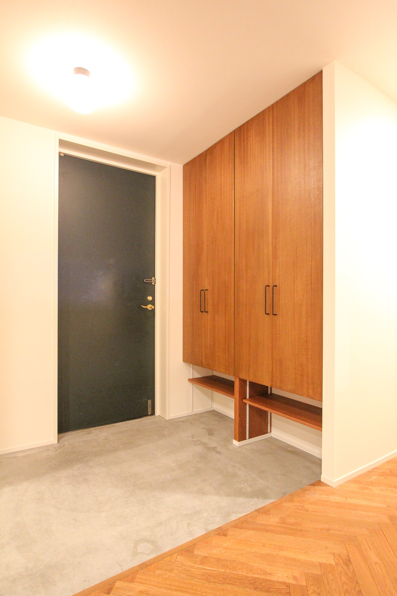 玄関事例：木製扉の下駄箱とモルタル仕上げの玄関（北欧ミッドセンチュリーの似合う家）