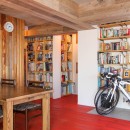 赤い床の山小屋ハウスの写真 自転車と本棚と丸太の壁