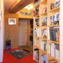 赤い床の山小屋ハウスの写真 木製の本棚と玄関土間