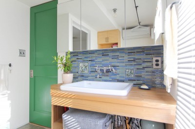 グリーンの扉とタイルのある洗面カウンター (赤い床の山小屋ハウス)