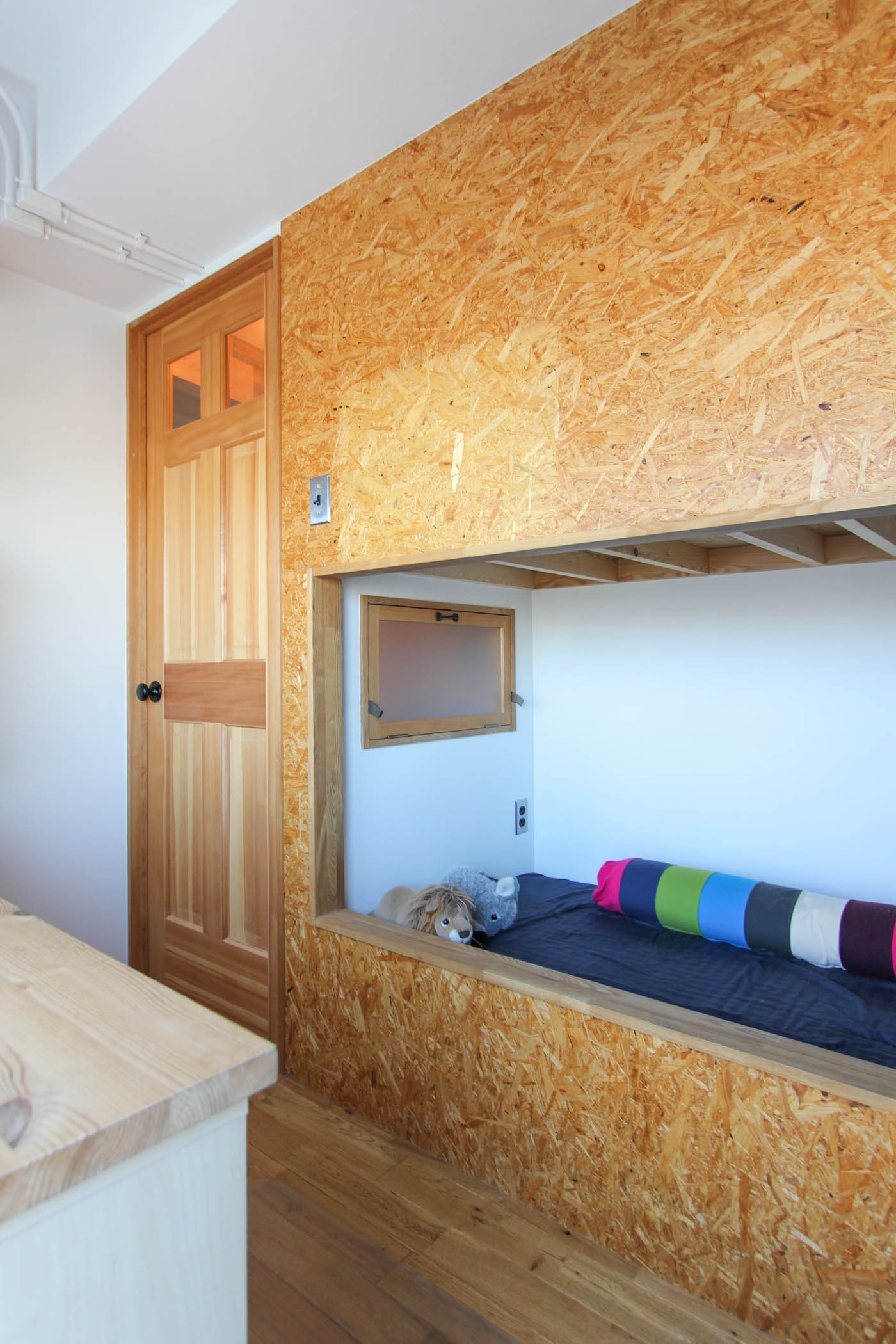 子供部屋事例：木製扉とOSBボードのベッド（赤い床の山小屋ハウス）