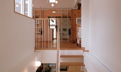 階段越しに2階のダイニングと、3階の子供スペースを見る｜浅草の家―２階にある庭