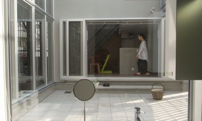 中庭越しにダイニングと繋がる洗面室｜コッソリッヒ　中庭を巻き込むようなスキップ空間