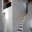 小さな吹抜けとペレットストーブの家の写真 ロフトヘの階段