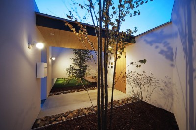玄関アプローチの夕景 (【komaki】塀をくぐると広がる開放感。移り変わる光、美しい景色や木肌が美しい平屋)