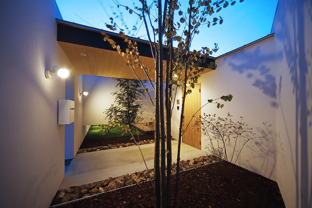 玄関事例：玄関アプローチの夕景（【komaki】塀をくぐると広がる開放感。移り変わる光、美しい景色や木肌が美しい平屋）