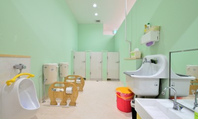 明るいグリーンの壁が特徴のトイレ｜横須賀市 ～にじのそら保育園～