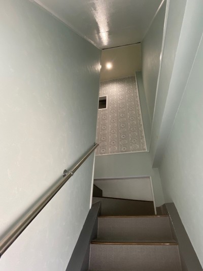 階段を上っていくうちに見えてくるアクセントウォール (築50年のビル改装、ワンフロアの改装後の階段リフォーム)