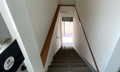 1階～2階はシンプルに。白の壁になっています。｜築50年のビル改装、ワンフロアの改装後の階段リフォーム