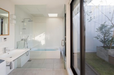 洗面所、浴室／プライバシーが守られたテラスに面する開放的な水回り。 (鶴見の家／線路沿いの細長い敷地に建つ木造３階建ての２世帯住宅)