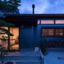 伊勢田の家／夫婦２人のためのコンパクトな平屋の住まいの写真 外観の夕景／LDKの高窓と格子からも暖かい光が漏れています。