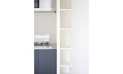 収納｜グレーホワイトな空間に、ネイビーの対面キッチンが空間の主役