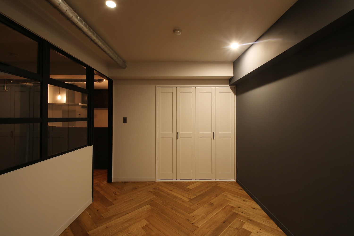ベッドルーム事例：居室（ヘリンボーンの床に、キッチンは塗装仕上げの木製モールディング）