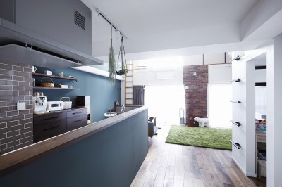 ブルーグリーンの壁が印象的な対面キッチン (溶け合うテイスト)