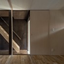 『RE長屋‐ITO２』～新：旧・モダン：和　のコラボ～（古民家再生）の写真 玄関横の部屋から階段をみる　／光を抑制した空間はシナ合板で明るく設えている。
