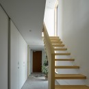 目黒の家〜天空光を取り込む家〜の写真 一階廊下．ヒノキ無垢材の階段と土間の連続のようなタイル床の対比