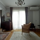 マントルピースの似合うマンションリノベの写真 アンティーク家具が馴染むリビングスペース