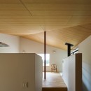 高山村の小さな家の写真 大空間を支える朱色の鉄骨柱と木合板仕上げの勾配天井