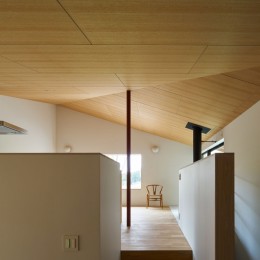 大空間を支える朱色の鉄骨柱と木合板仕上げの勾配天井 (高山村の小さな家)