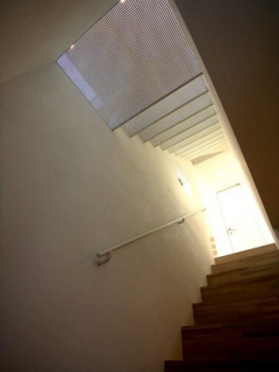 階段見上げ。２階→３階の階段はパンチングメタルでできており、光が透過します。 (昭島の家)