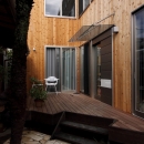 緑豊かな敷地環境を継承する木造スケルトンハウスの写真 ウッドデッキ～エントランス