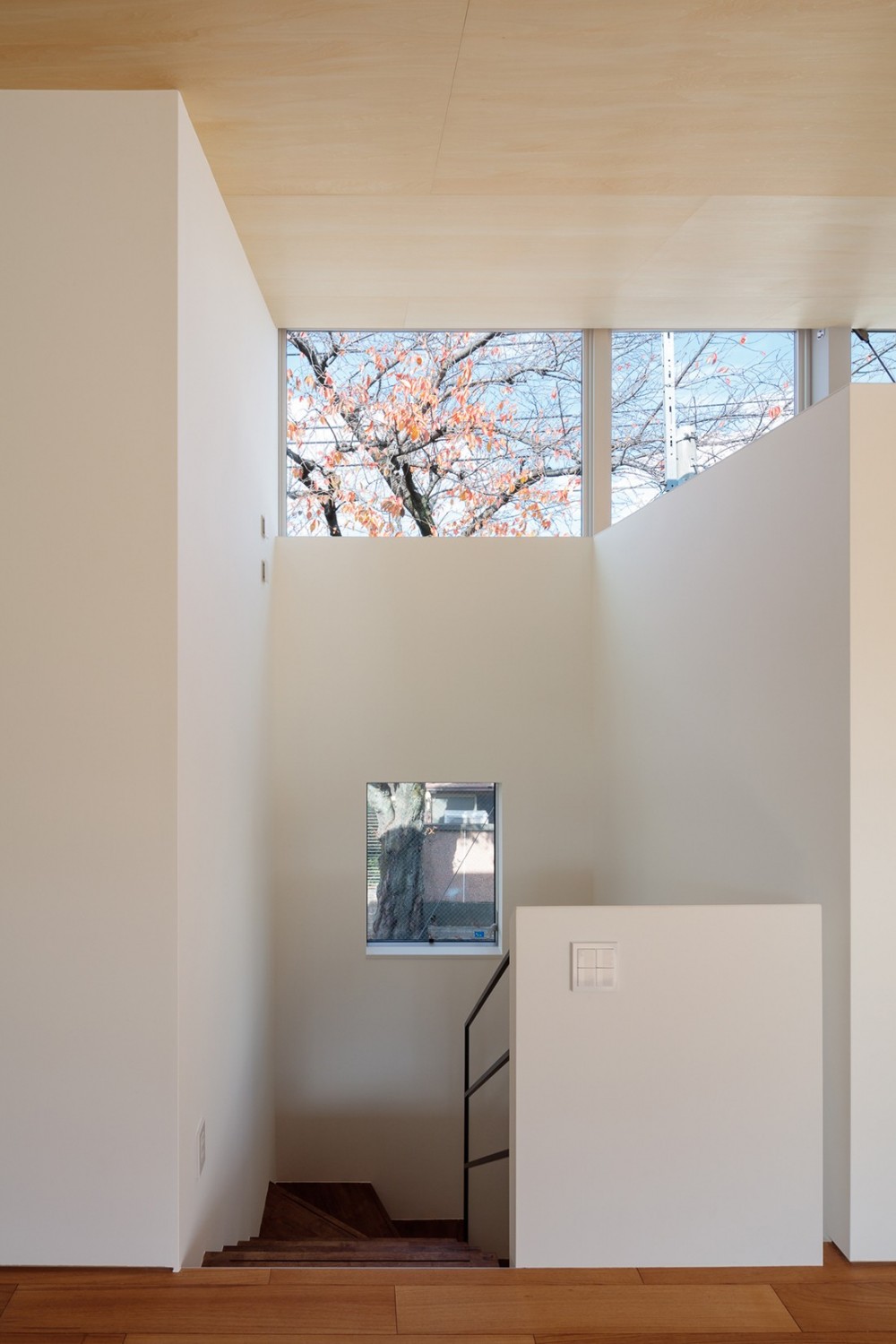 桜並木と暮らす家［こだわりのキッチンとバーベキューもできるデッキテラス］ (階段降り口から高窓を見る)