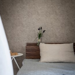 シンプルで落ち着いた壁紙が自然と部屋に馴染む。風合いを演出するデザイン。 (居室)