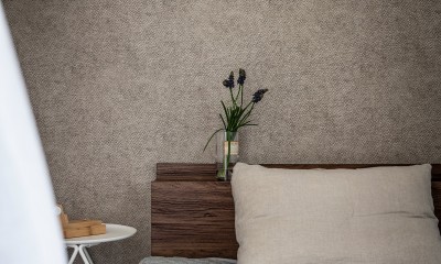 シンプルで落ち着いた壁紙が自然と部屋に馴染む。風合いを演出するデザイン。 (居室)